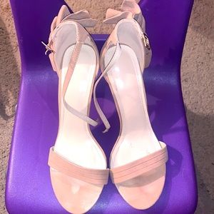 Open toe high heel sandals with ankle strap and fringe on the back of the heel